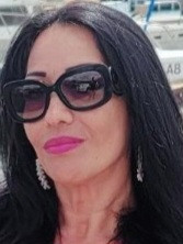 Black hair, tan, with prescription sun glasses.