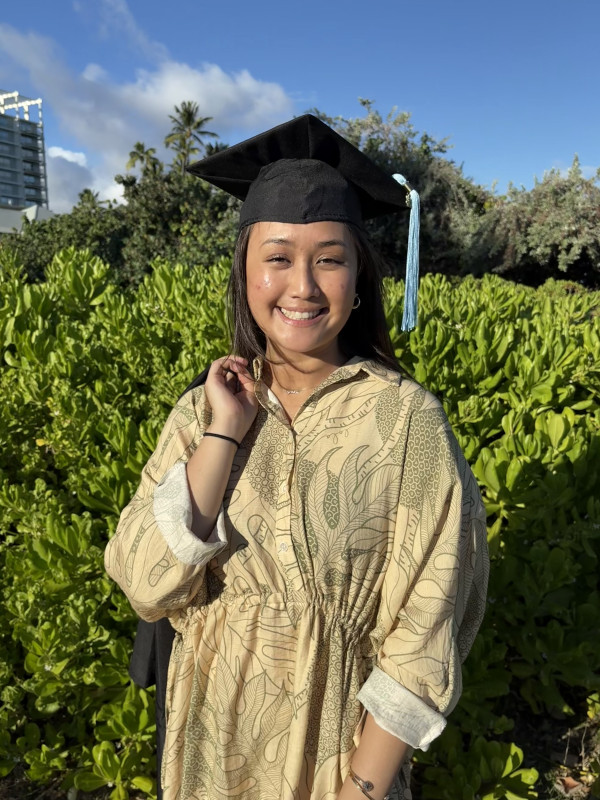 Picture of me with a cap on my head and gown over my shoulder.