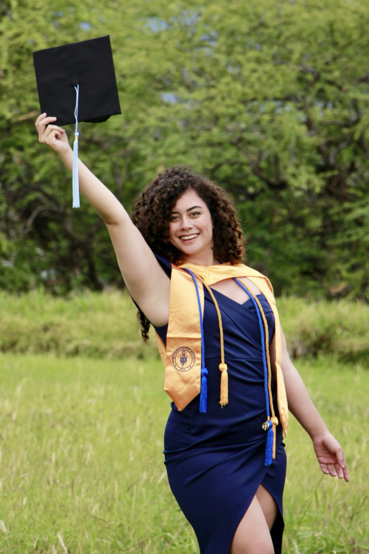 Graduate smiling with cap in hand
