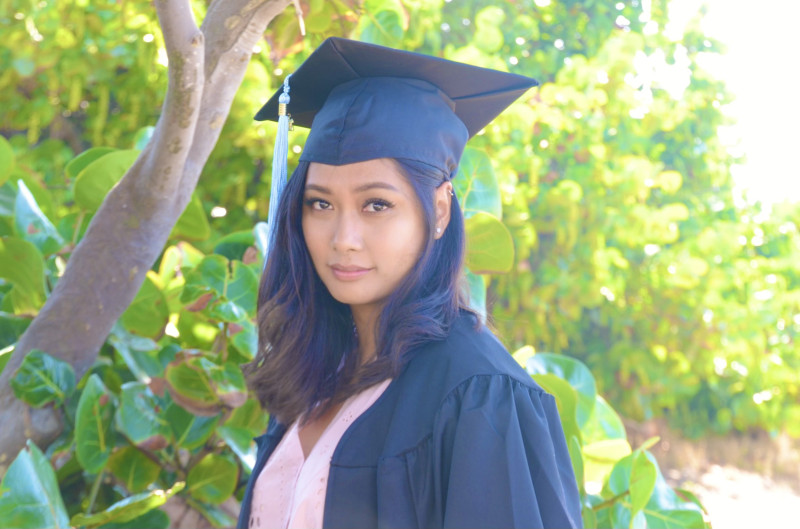 I'm wearing a black graduation gown and cap.