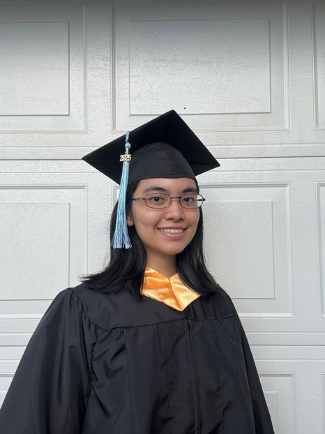 A half-length portrait photo of myself wearing the LEE CC cap, gown, and honors hood.  There is a white brick patterned background. I'm doing a slight 3/4 portrait pose.